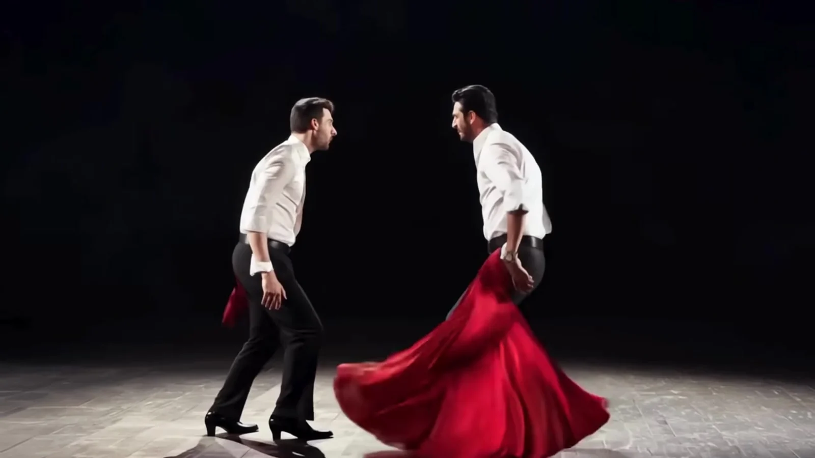 Fotograma del videoclip de «Carta de recomendación»: una falda roja se abre en pleno giro sobre la tarima de madera mientras el otro bailarín espera al otro lado