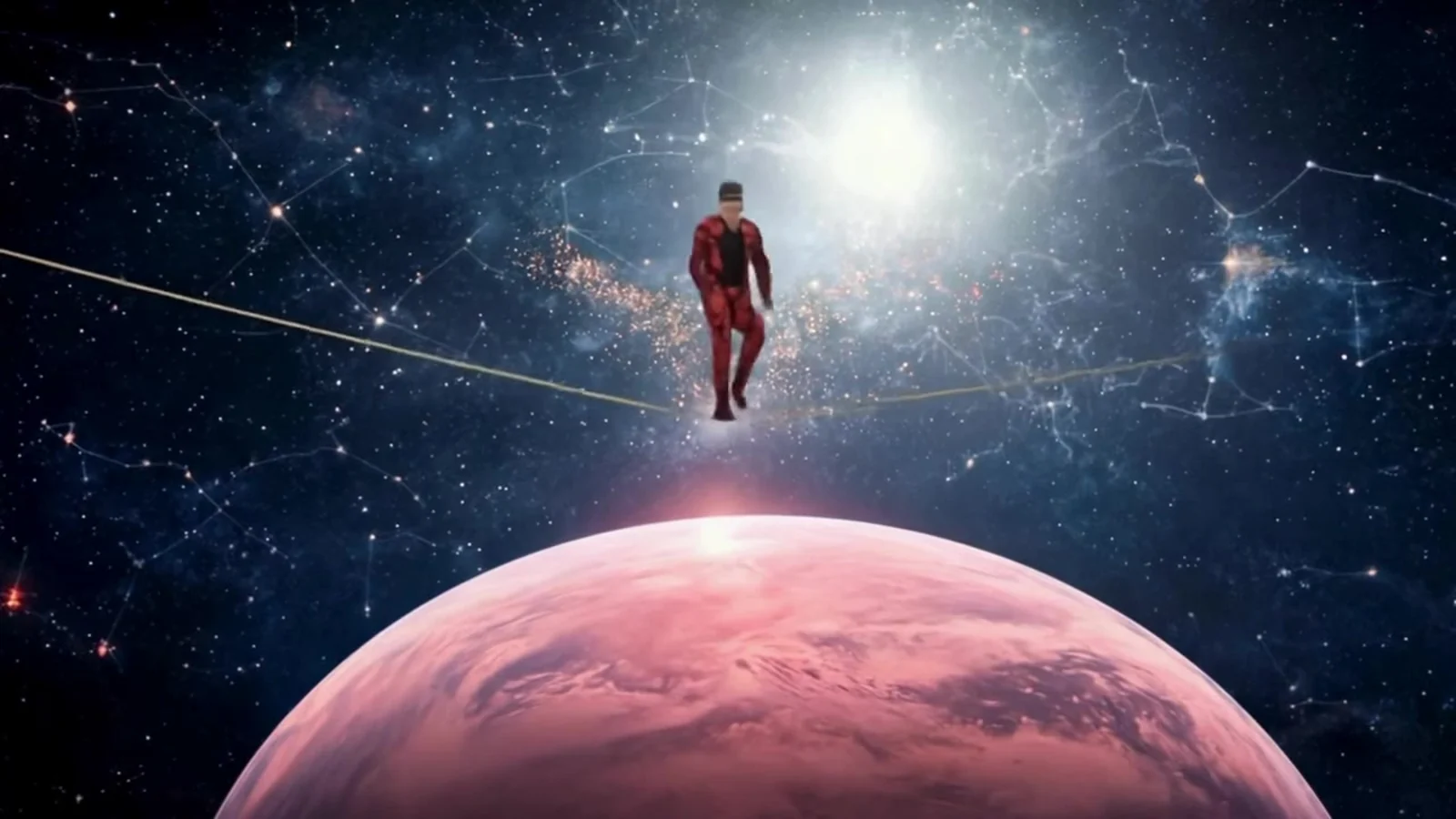 Fotograma del videoclip de «Punto muerto»: una figura diminuta con traje rojo camina por una cuerda floja sobre un planeta rosa, entre constelaciones