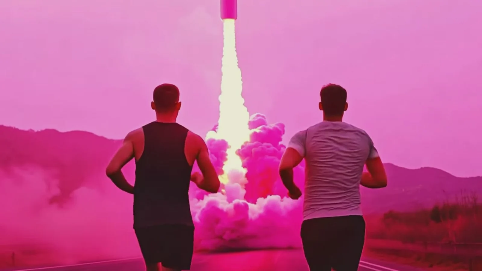 Fotograma del videoclip de «Ya no te quiero»: dos chicos vistos de espaldas, uno con camiseta de tirantes negra y otro con camiseta gris, corren por un camino hacia un cohete que despega entre humo rosa y montañas fucsias