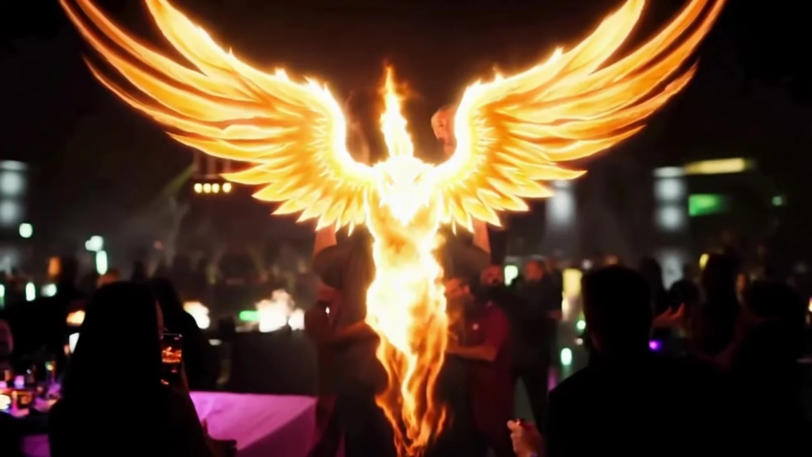 Fotograma del videoclip de «Tattoo de fénix»: un fénix de fuego dorado con las alas abiertas sobre una discoteca llena de gente con luces moradas