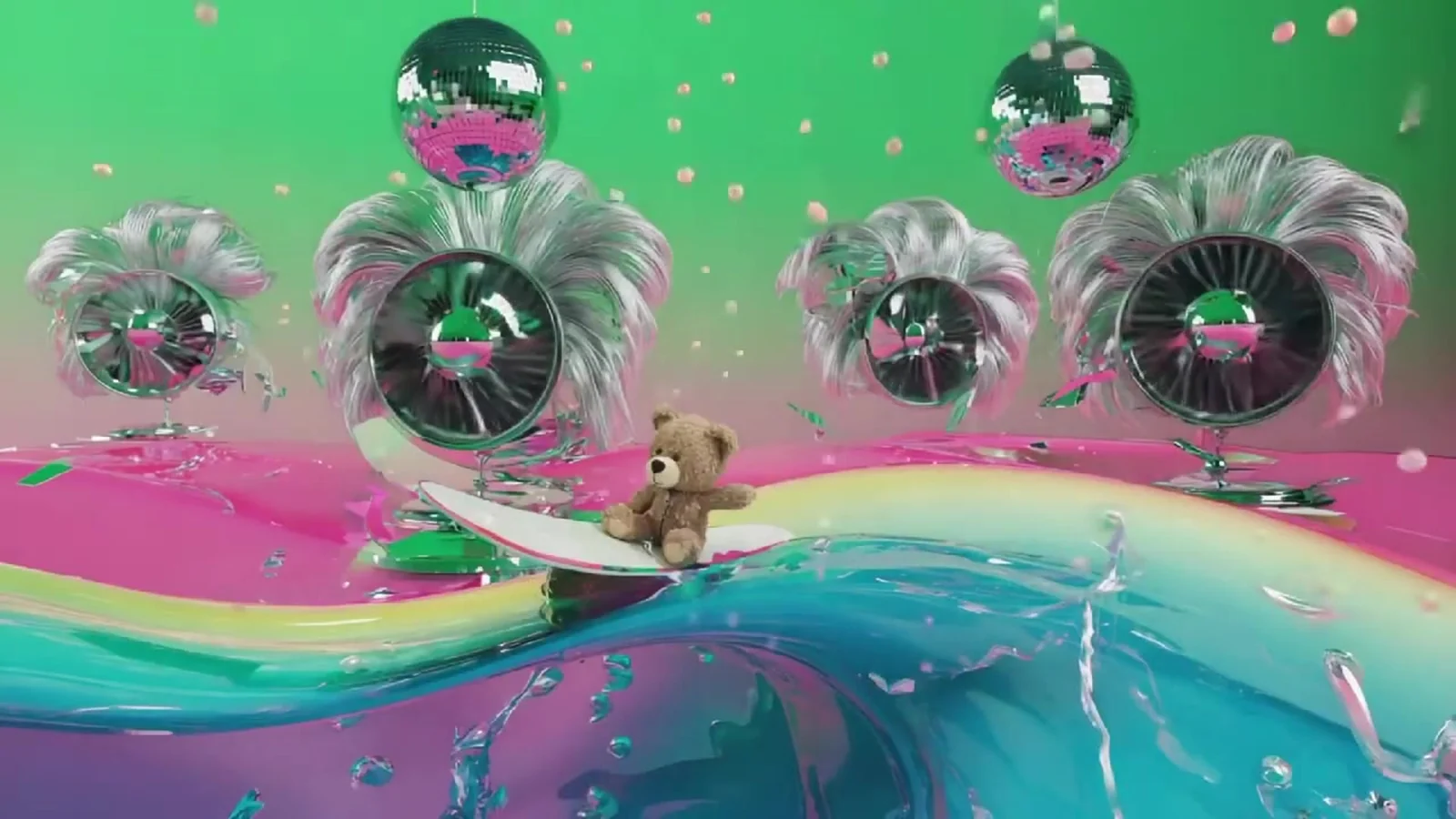 Fotograma del videoclip de «Veneno»: un oso de peluche surfea una ola de colores verde, rosa y turquesa entre bolas de espejos y ventiladores con plumas