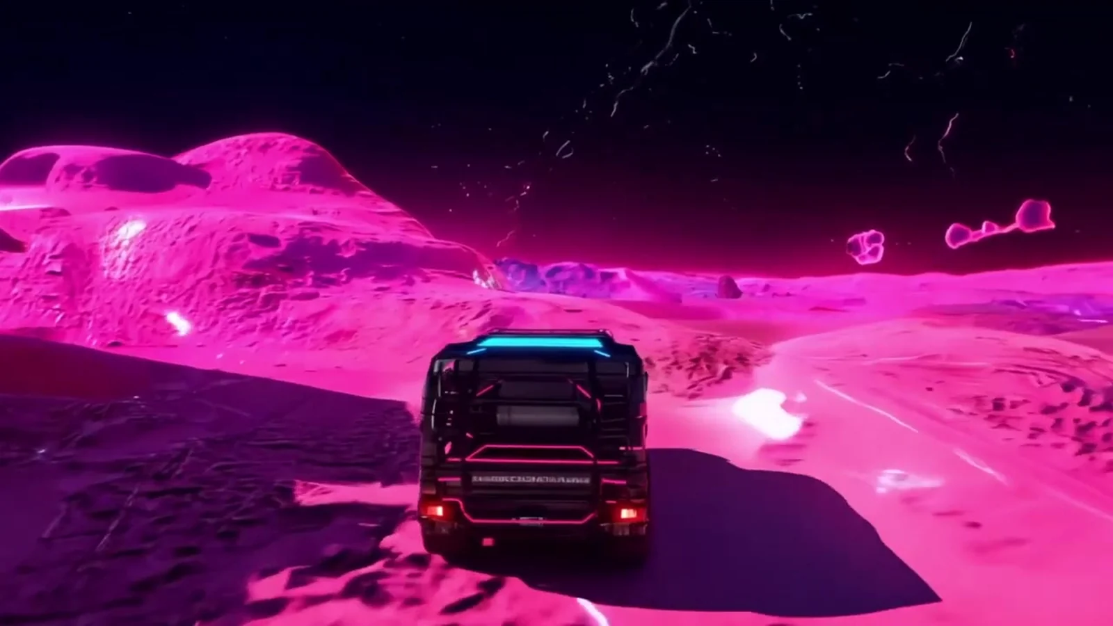 Fotograma del videoclip de «Ojalá se pudiera viajar a GAYFOLK»: un todoterreno visto desde atrás avanza entre dunas de color rosa intenso bajo un cielo negro con estrellas