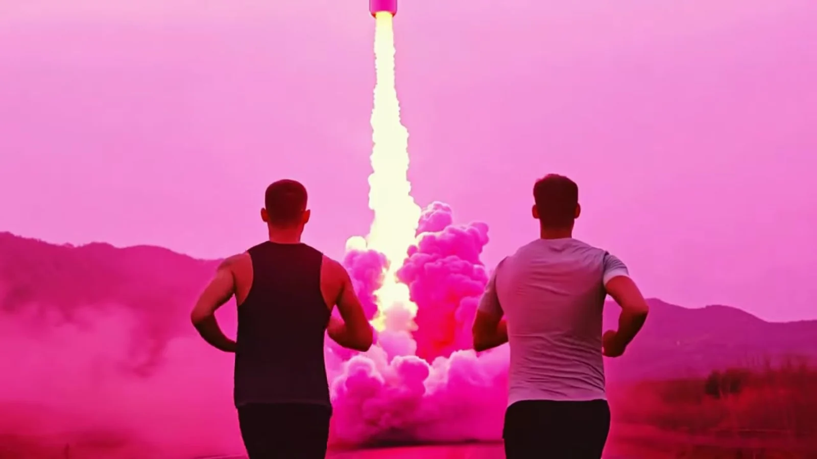 Fotograma del videoclip de «Ya no te quiero»: dos chicos de espaldas corren hacia un cohete que despega entre humo rosa bajo un cielo rosa