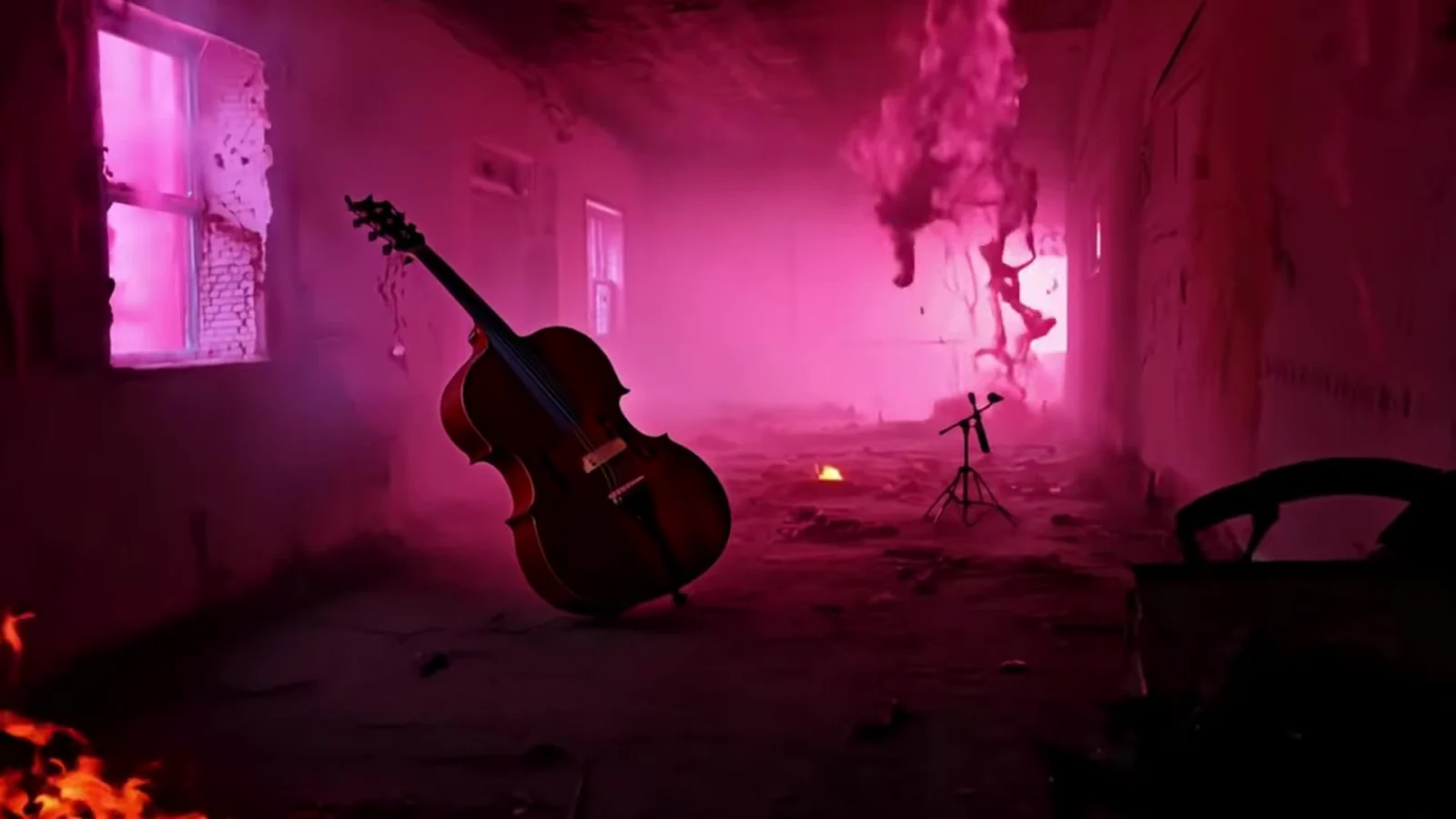 Fotograma del videoclip de «¡Vaya director!»: un violonchelo apoyado contra la pared agrietada de una habitación en ruinas, con brasas en una esquina, humo rosa y una ventana iluminada
