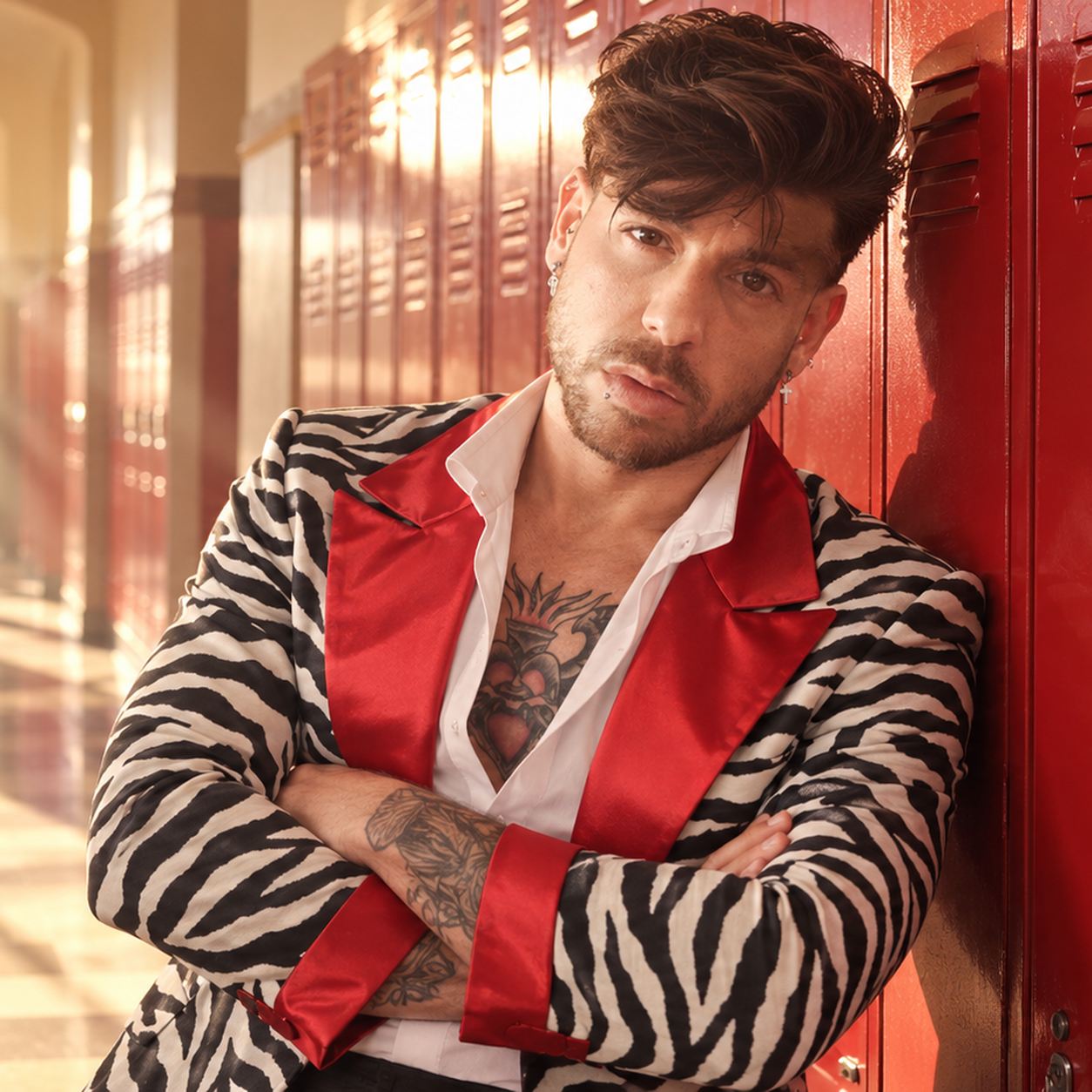 Mike Sain't Louis con chaqueta de cebra y solapas rojas apoyado en unas taquillas rojas de un pasillo escolar