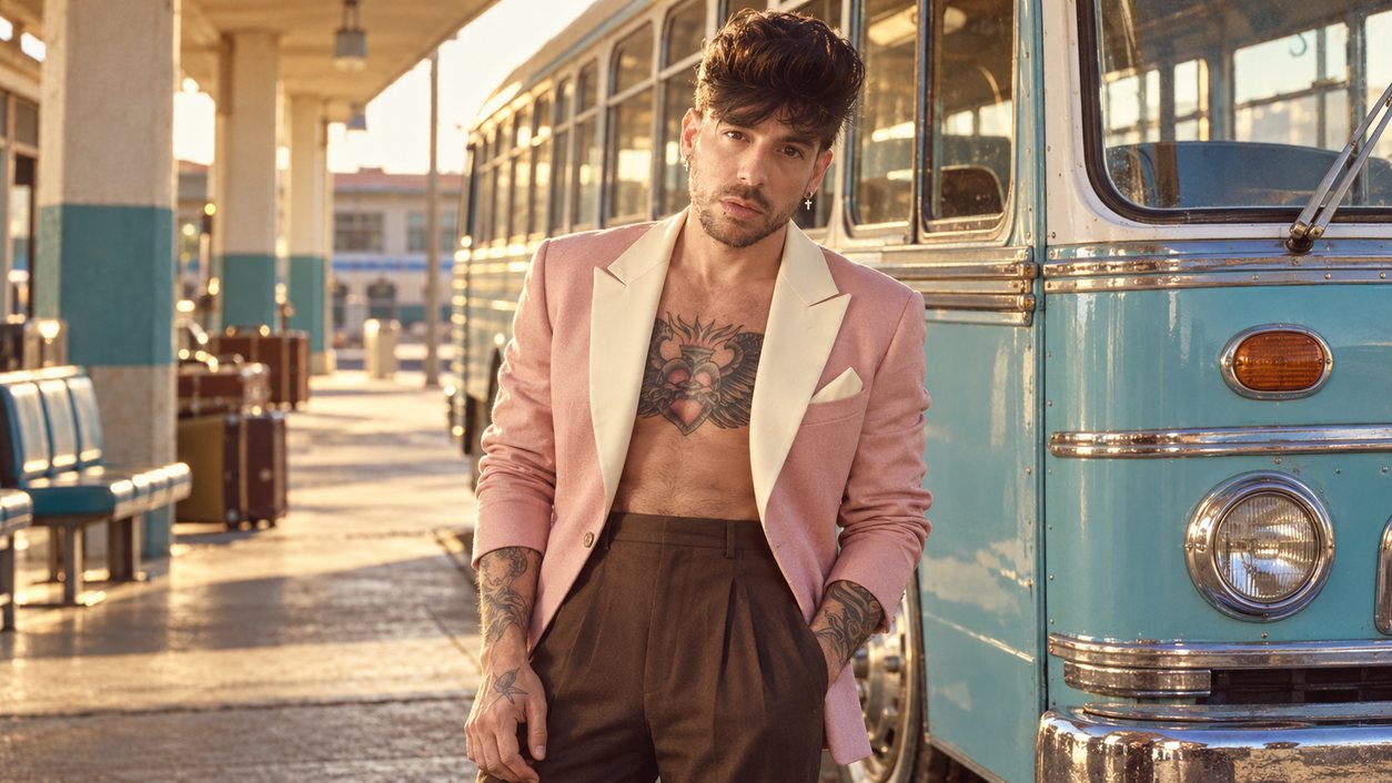Mike Sain't Louis con americana rosa y pantalón marrón junto a un autobús clásico azul claro (serie 100 fotos retro, n.º 057, en color)