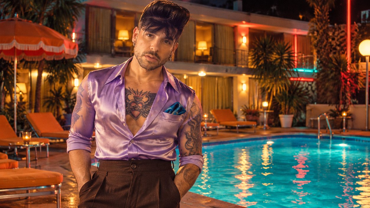 Mike Sain't Louis con camisa satinada lila junto a la piscina iluminada de un motel de noche (serie 100 fotos retro, n.º 070, en color)